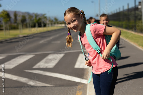 Schoolgirl looking for traffic while waiting to cross the road