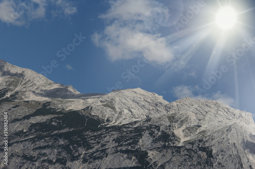 Mountains, sun and blue sky on summer day. Beautiful mountain background