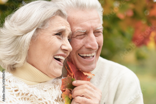 Portrait of beautiful senior couple with leaves in the park