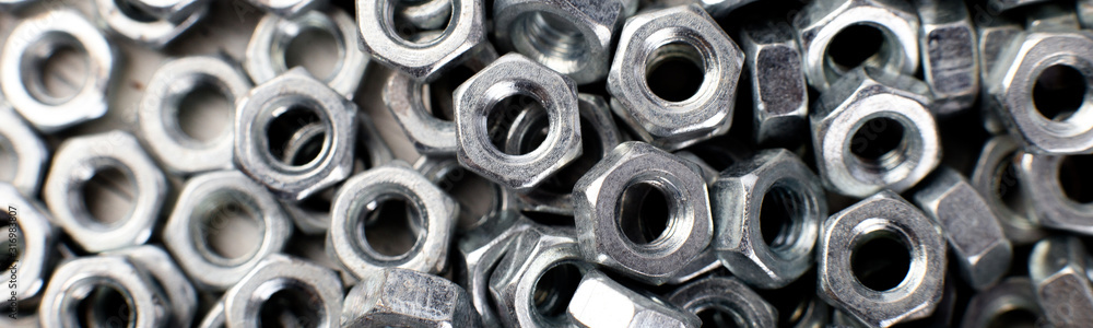 Banner of Metal nuts background. Macro. Working tools. Fixing elements.