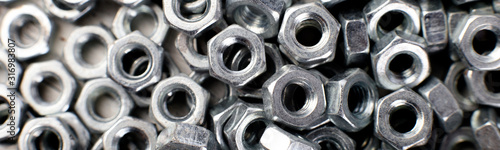 Banner of Metal nuts background. Macro. Working tools. Fixing elements. photo