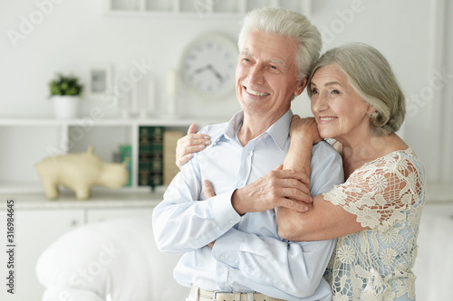 Portrait of cheerful senior couple embracing at home © aletia2011