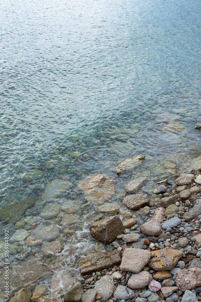 abstract sea background with stones underwater and on the shore. Vertical orientation abstract sea background with stones underwater and on the shore. Vertical orientation