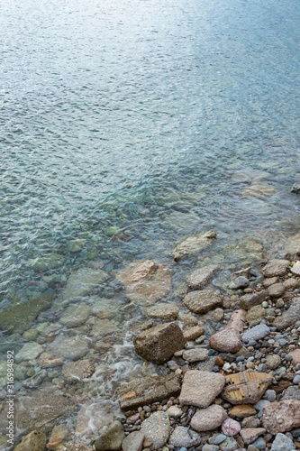 abstract sea background with stones underwater and on the shore. Vertical orientation