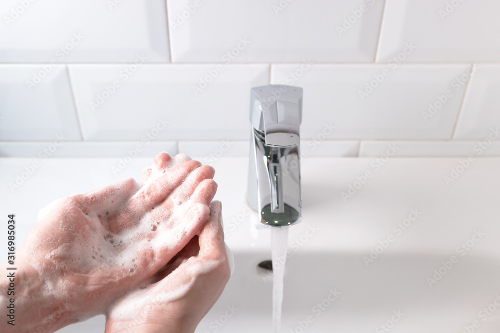 Washing hands over the sink with water stream in the bathroom, indoors. Concept healthcare and hygiene, daily routine Stock Photo | Adobe Stock Washing hands over the sink with water stream in the bathroom, indoors. Concept healthcare and hygiene, daily routine Stock Photo | Adobe Stock