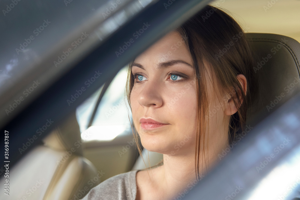 Young attractive caucasian woman behind the wheel driving a car with serious face expression. Attentive look, bright blue eyes. Copy space. Young attractive caucasian woman behind the wheel driving a car with serious face expression. Attentive look, bright blue eyes. Copy space.