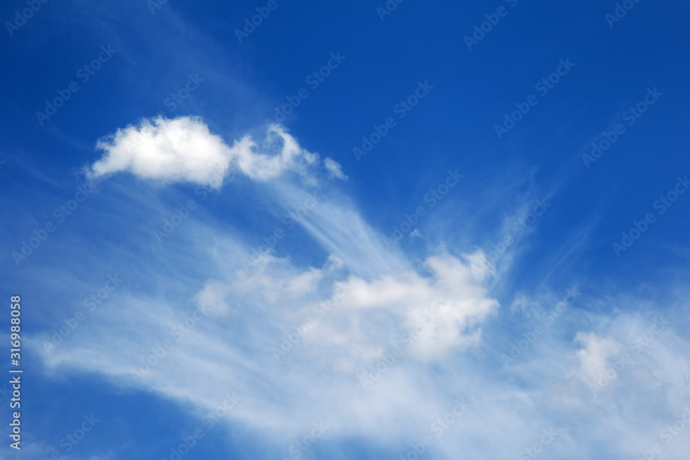 Background sky on a bright sunny day. Beautiful cumulus and cirrus thin clouds on a blue sky background. Blank for nature design