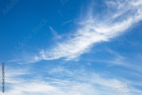 Background sky on a bright sunny day. Beautiful cumulus and cirrus thin clouds on a blue sky background. Blank for nature design