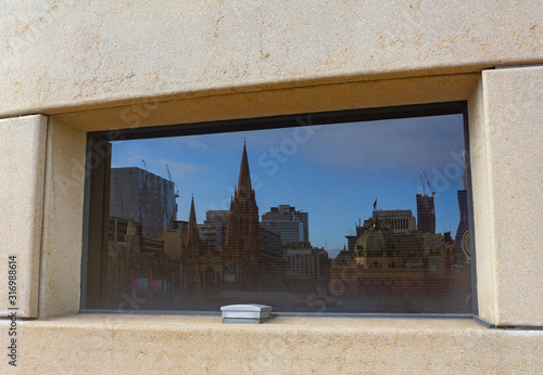  A reflection of Melbourne CBD tourist landmarks in the window of the Melbourne Arts Centre, Victoria, Australia