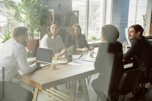 Teambuild. Group of young business professionals having a meeting. Diverse group of coworkers discuss new decisions, future plans, results, strategy. Creativity, workplace, business, finance, teamwork