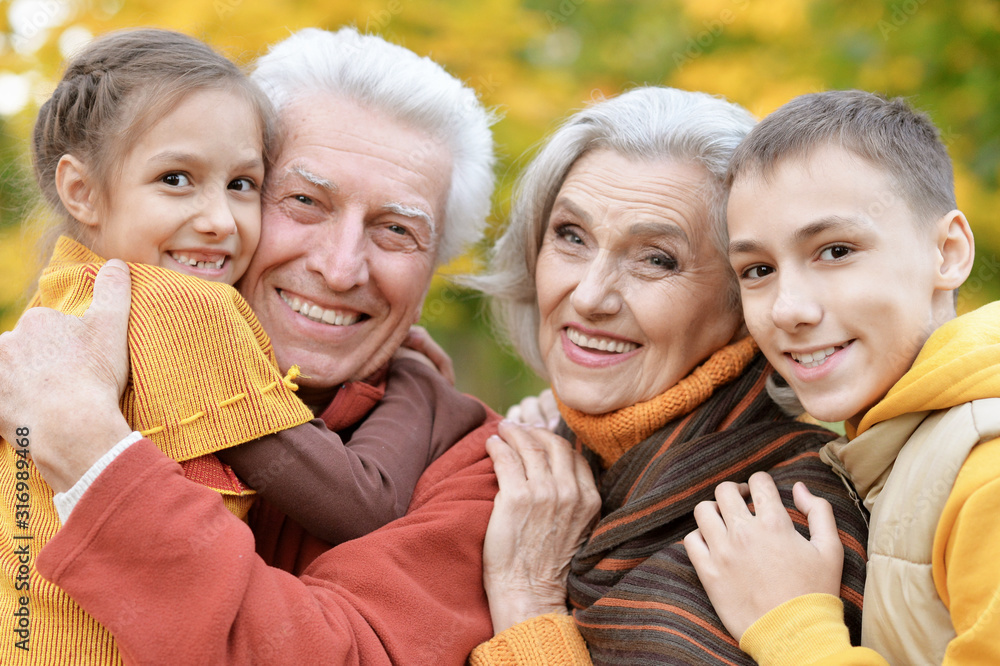 Fototapeta premium Happy grandfather, grandmother and grandchildren in park