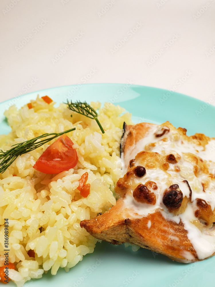 Grilled salmon with white rice on a plate on a white background. fish fillet with rice close up.