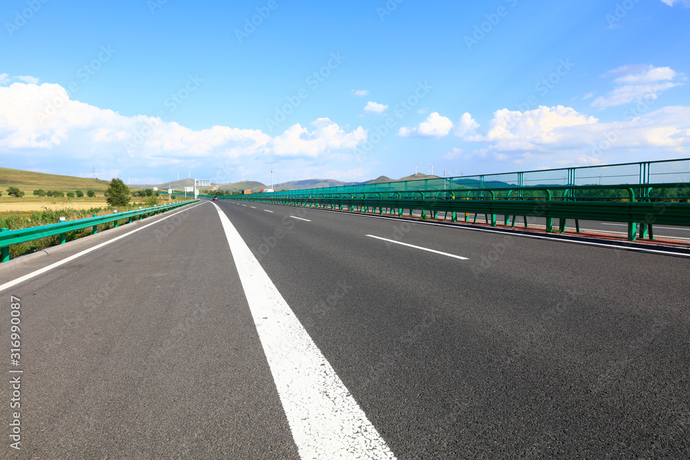 Fototapeta premium Empty highway, blue sky and white clouds landscape