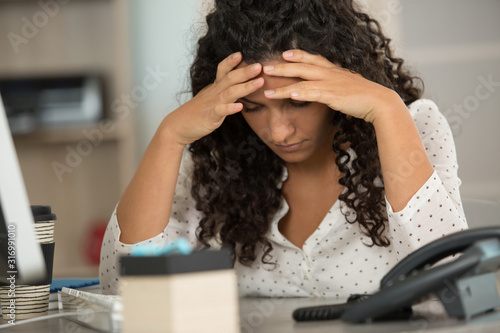 young woman stressed at work photo