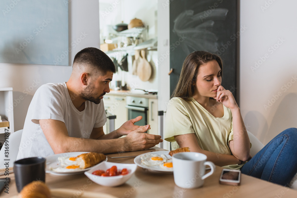 young couple arguing in kitchen during breakfast. relationship problems young couple arguing in kitchen during breakfast. relationship problems