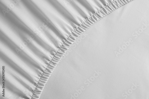 Foto Bed corner with white fitted sheet