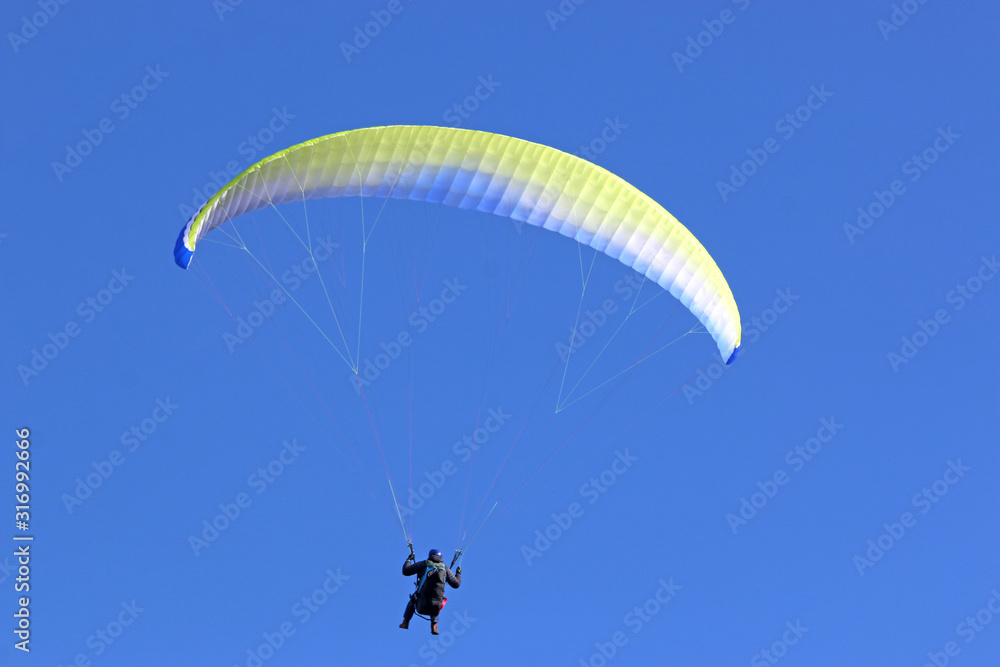 Paraglider flying wing in a blue sky Paraglider flying wing in a blue sky