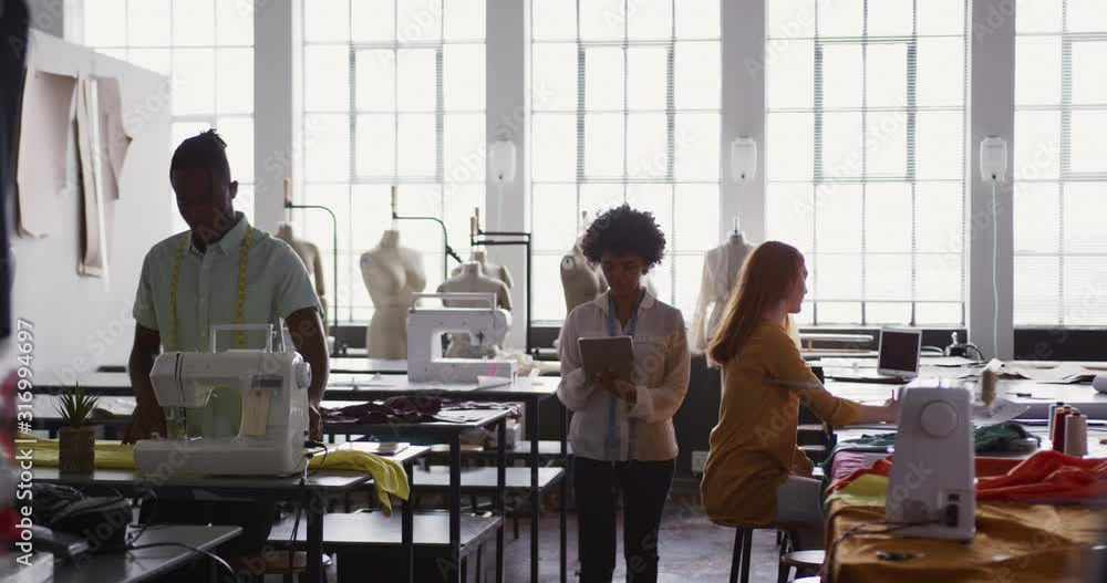 Three colleagues working separately in fashion office Three colleagues working separately in fashion office