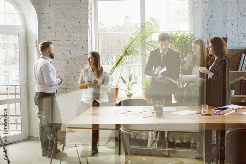 Second family. Group of young business professionals having a meeting. Diverse group of coworkers discuss new decisions, plans, results, strategy. Creativity, workplace, business, finance, teamwork.