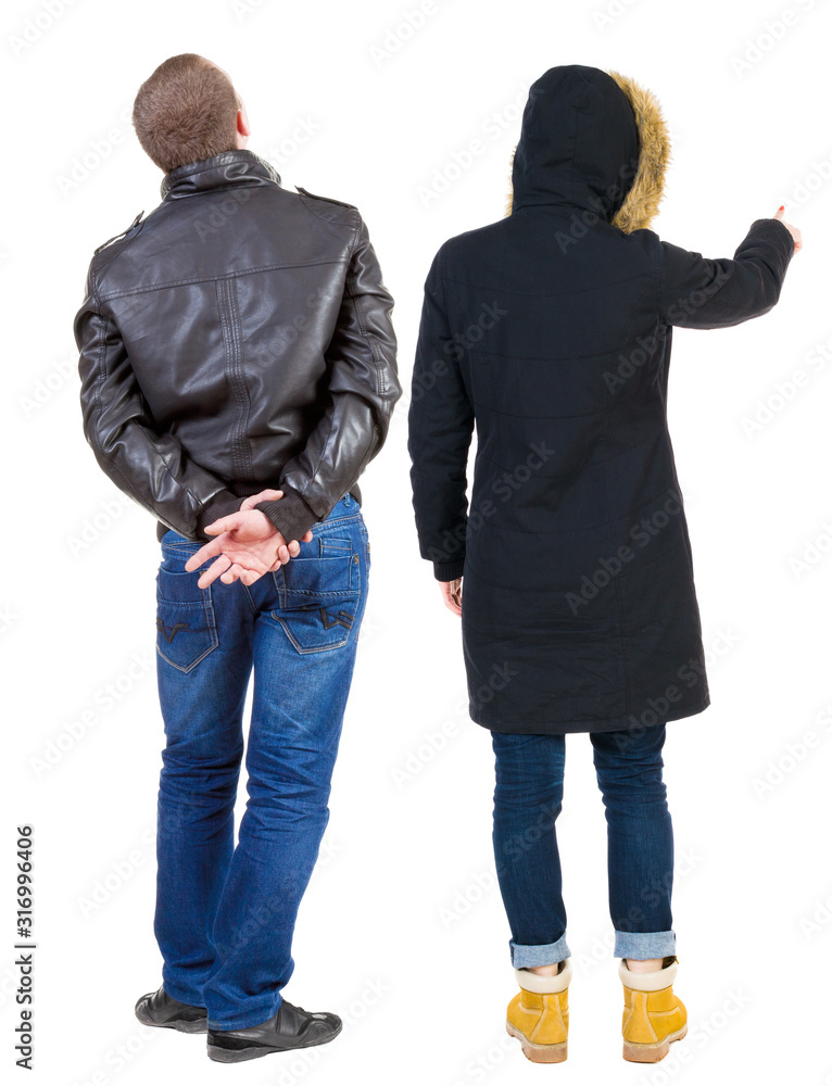 Back view of couple couple in winter jackets pointing. Back view of couple couple in winter jackets pointing.