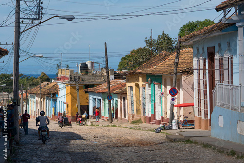 old trinidad street with many colorful houses and people, cuba © André Gerken
