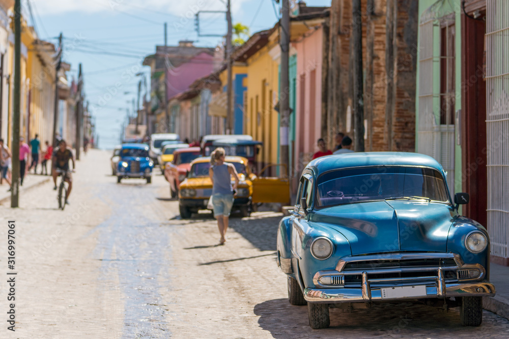 classic cars on a colorful street in trinidad, cuba