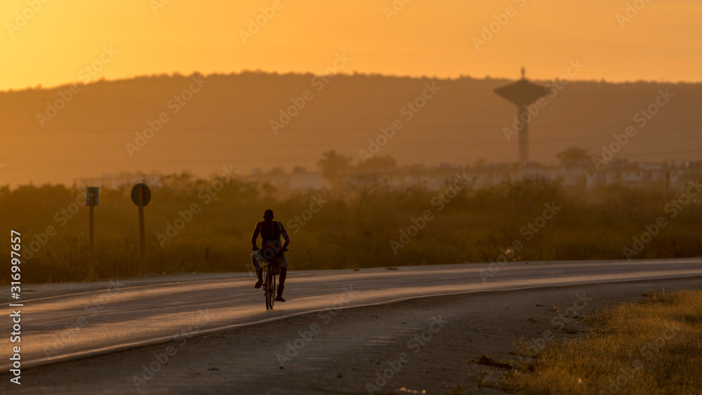 man riding a bike in sunset man riding a bike in sunset
