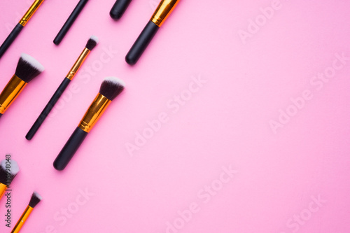 Creative arrangement of cosmetics products on pink background.