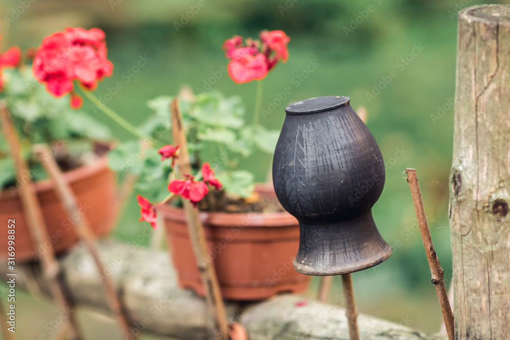 black clay pot on a wicker fence.