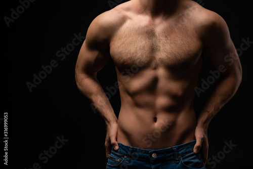 cropped view of sexy man in jeans with bare muscular torso isolated on black