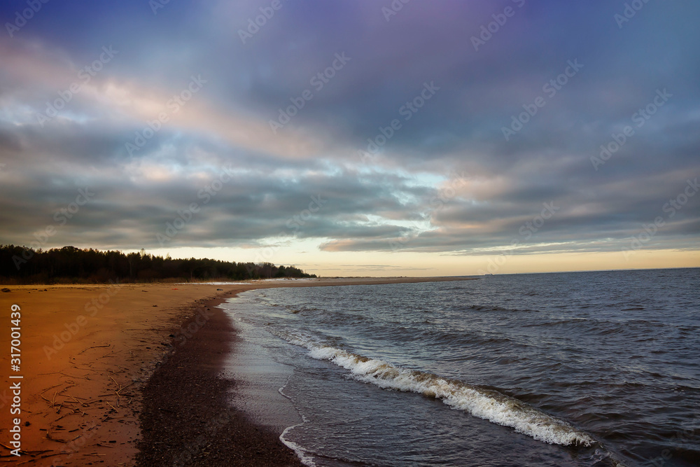 Sunset on the deserted beach of the Gulf of Finland in winter.