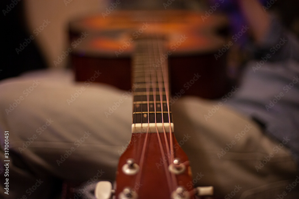 Fototapeta premium Musical instrument acoustic guitar. Home playing guitar lessons. Exercises for the development of musicality. Screw tool.