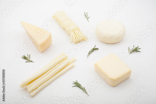 Types of cheese, hard, pigtails, in a beautiful composition, highlighted on a white background . The concept of types of cheese or dairy products containing calcium.