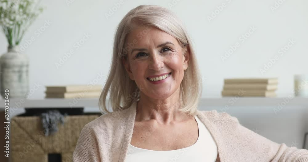 Happy older middle aged woman looking at camera at home Happy older middle aged woman looking at camera at home