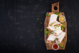 Fresh tortilla wraps with chicken and fresh vegetables on wooden board. Chicken burrito. Mexican food. Healthy food concept. Mexican cuisine.Top view, overhead