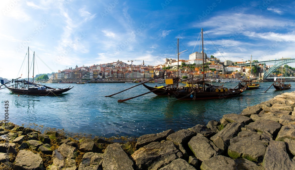 Portugal, city landscape Porto, wooden boats with wine port barrels on Douro river, panoramic view of the old town Porto,  The Eiffel Bridge view, Ponte Dom Luis, Porto in summer, colored houses