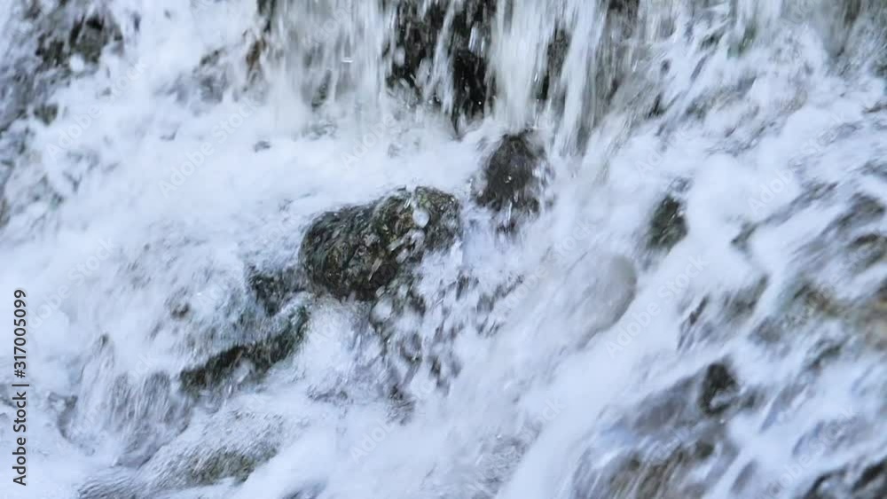Catarata en cámara lenta y roca salpicada por caída de agua Catarata en cámara lenta y roca salpicada por caída de agua