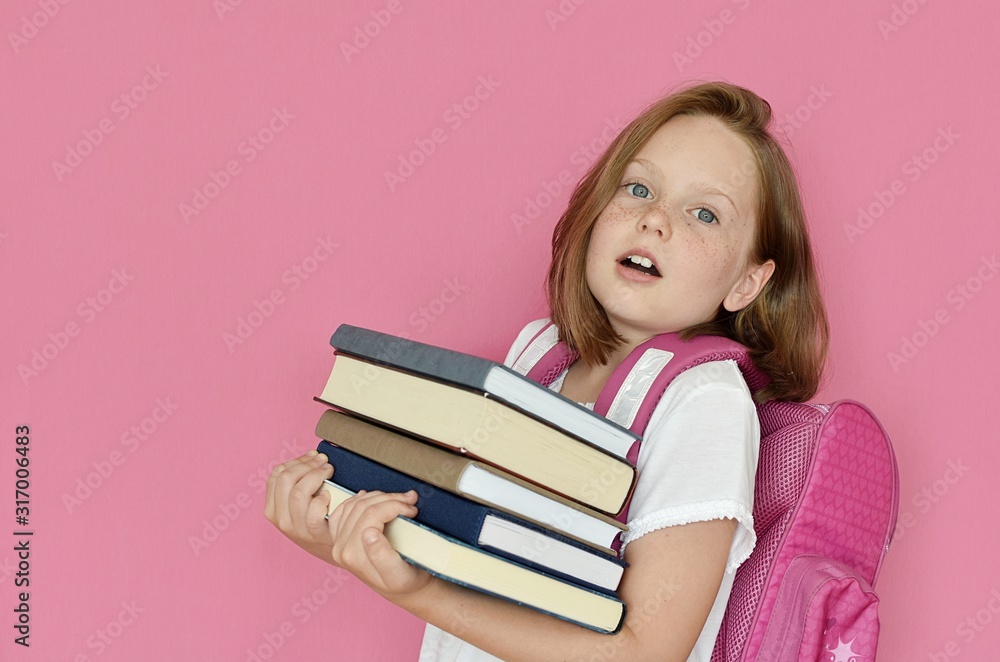 Pupil girl holding heavy books in hands, education, back to school, reading concept. Pupil girl holding heavy books in hands, education, back to school, reading concept.