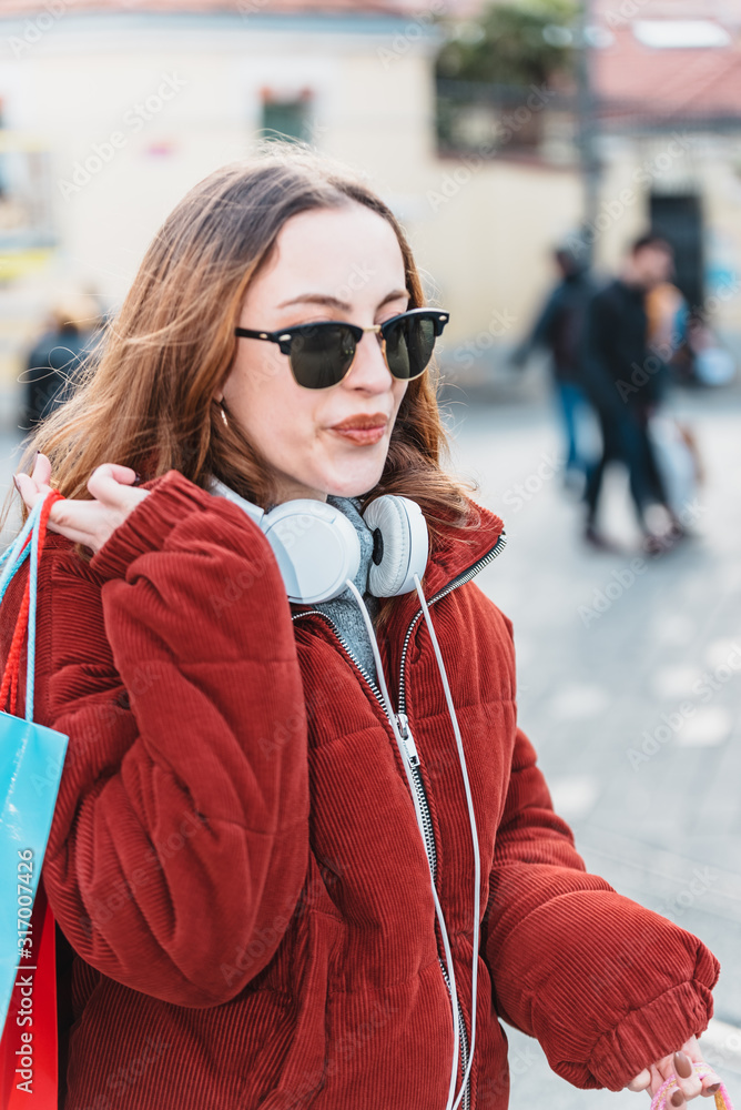 Fototapeta premium Beautiful young girl walks with shopping bags