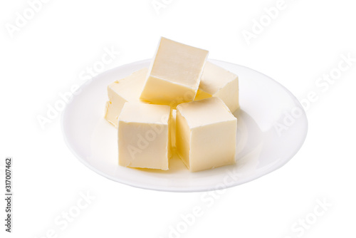 Butter pieces in ceramic bowl isolated on white background