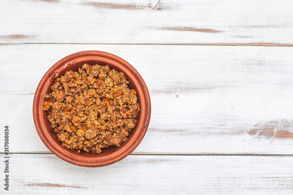 Grilled minced meat in a plate on a light wooden background.