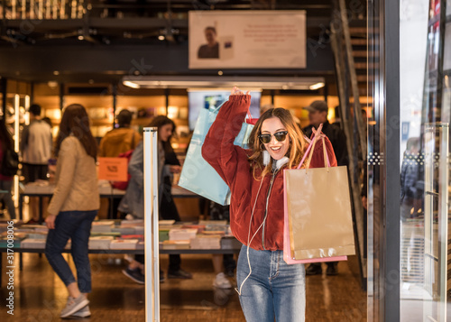 Beautiful young woman exits from clothes Shop