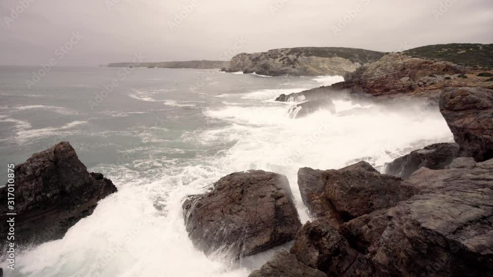 Waves crashing into the coastline of portugal making little waterfalls Waves crashing into the coastline of portugal making little waterfalls