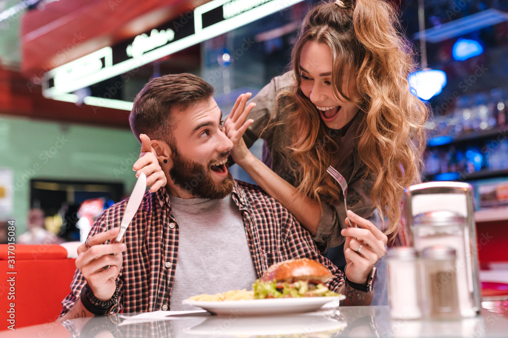 Girl covering eyes of her boyfriend in cafe. Girl covering eyes of her boyfriend in cafe.