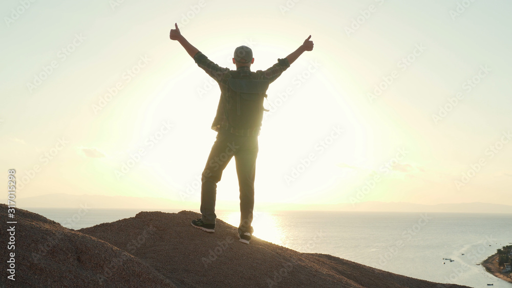 Senior traveler raise his hands in success gesture at sunrise