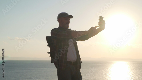 Senior traveler male making selfie with smartphone
