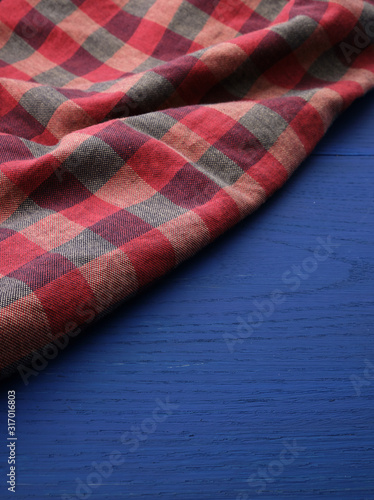 red checkered fabric on a blue wooden background
