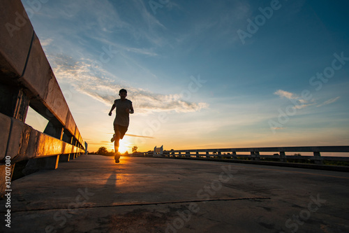 Athlete runner feet running on road, Jogging at outdoors. Man running for exercise.Sports and healthy lifestyle concept. © sutadimages