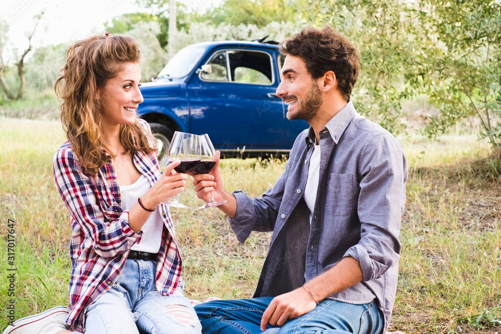Fototapeta premium Beautiful couple in love having a picnic drinking wine