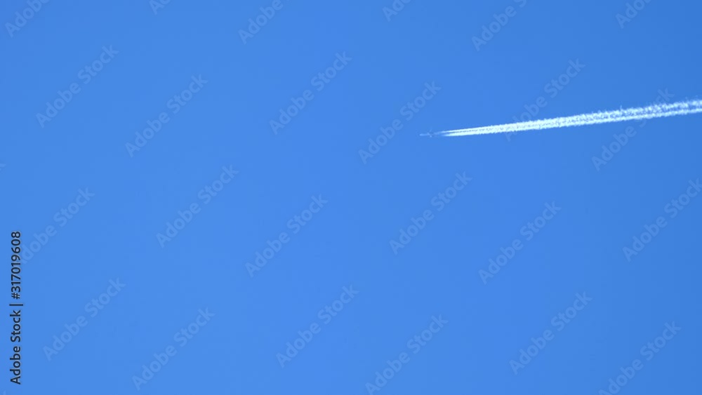 airplane and airplane trail high in clear blue sky airplane and airplane trail high in clear blue sky